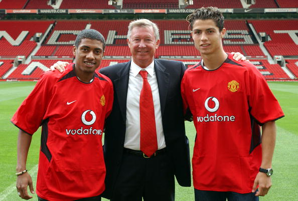 STOKE, ENGLAND - AUGUST 13:  Sir Alex Ferguson poses with Kleberson and Cristiano Ronaldo for photographers at Old Trafford on August 13, 2003 in Manchester, England.  (Photo by John Peters/Manchester United via Getty Images)