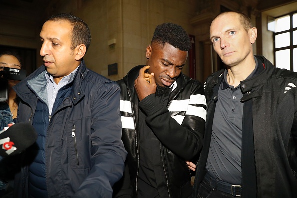 Paris Saint-Germain's defender Serge Aurier (C) arrives to the Paris courthouse early on September 26, 2016 to answer a charge of elbowing a police officer. The 23-year-old Ivory Coast international is accused of assaulting a police officer after he was stopped in May 2016 when leaving a Parisian nightclub in the early hours of the morning. / AFP / PATRICK KOVARIK (Photo credit should read PATRICK KOVARIK/AFP/Getty Images)